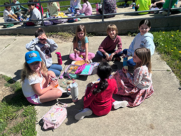 Students sitting coloring with chalk